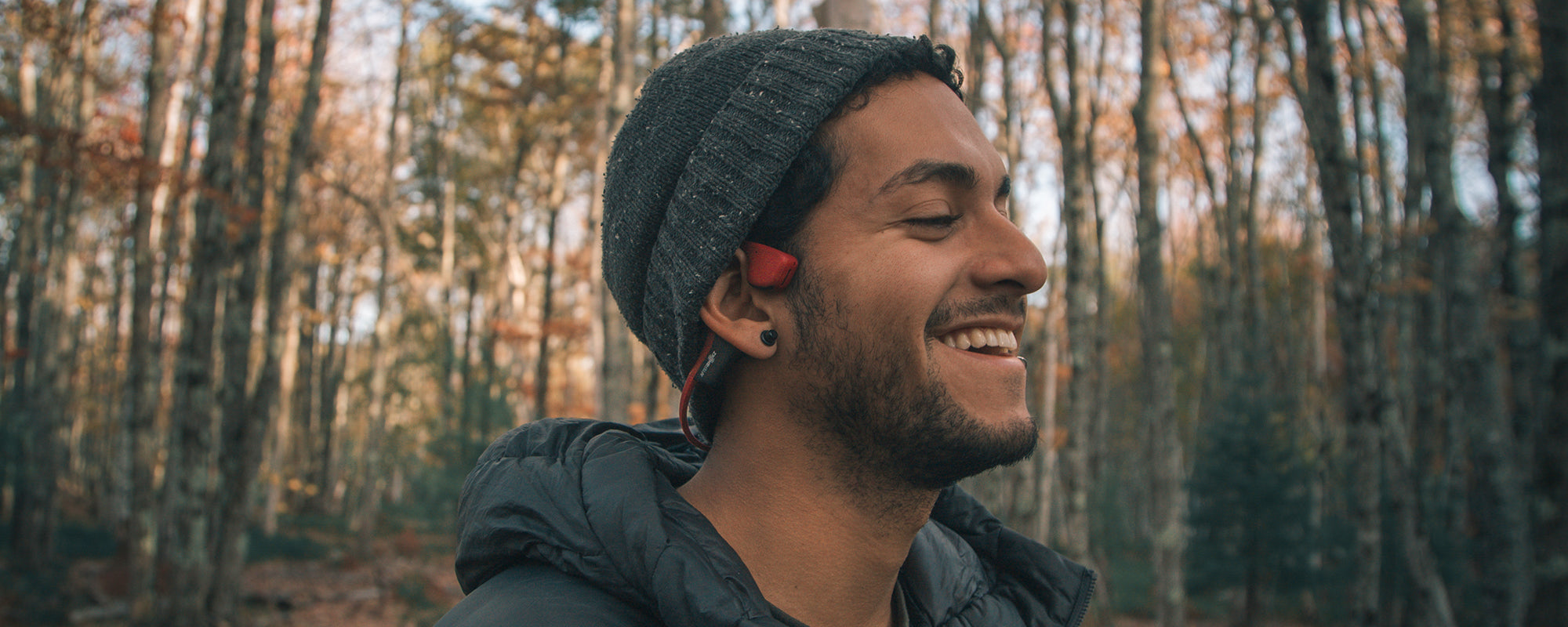 Man outdoors in forrest wearing AfterShokz Air headphones