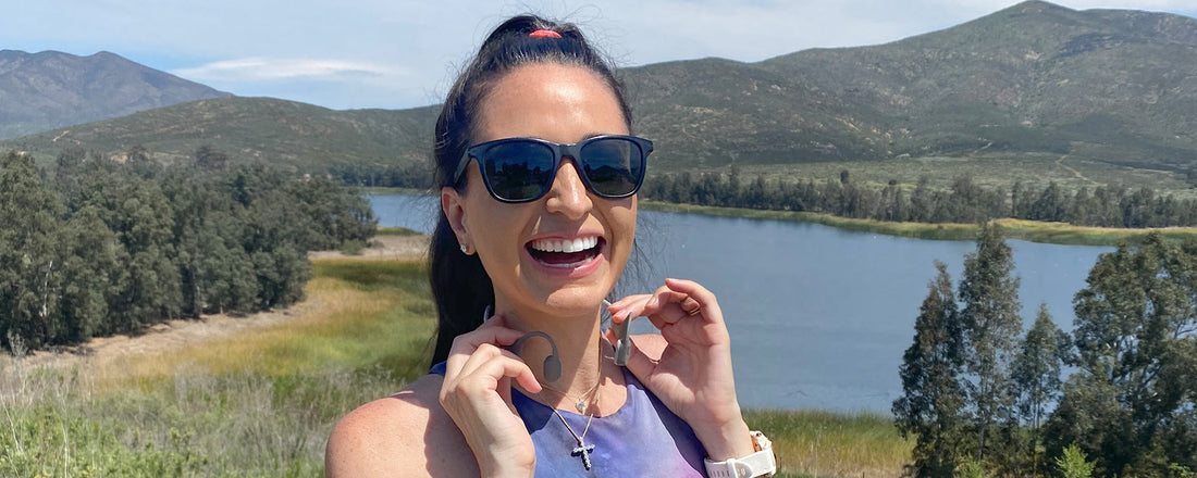 Woman putting on AfterShokz Aeropex wireless headphones
