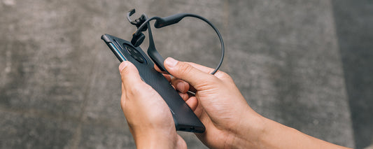 Person using NFC Pairing to sync AfterShokz OpenComm headset to device