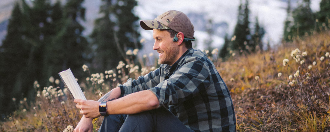 Man meditating in forrest while wearing AfterShokz Air wireless headphones