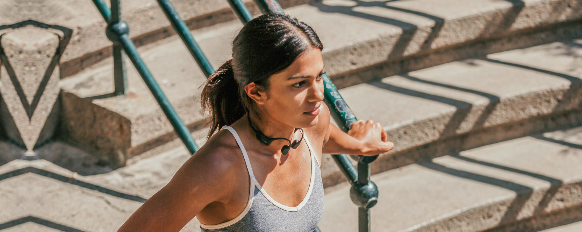 Woman doing outdoor workout while wearing AfterShokz Aeropex wireless headphones