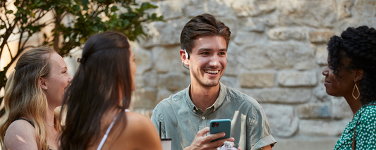 Group of friends talking and wearing AfterShokz wireless headphones