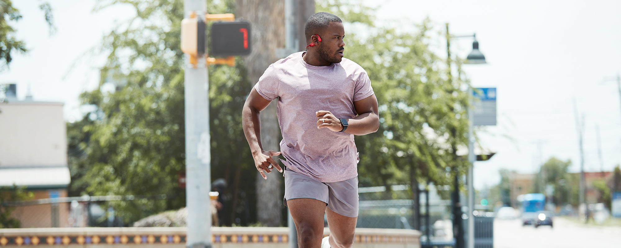 Man running in the city while wearing AfterShokz Aeropex headphones