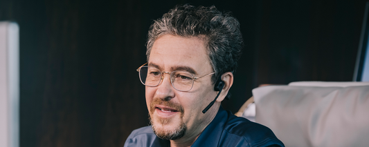 Man wearing the AfterShokz OpenComm headset while on a work video call