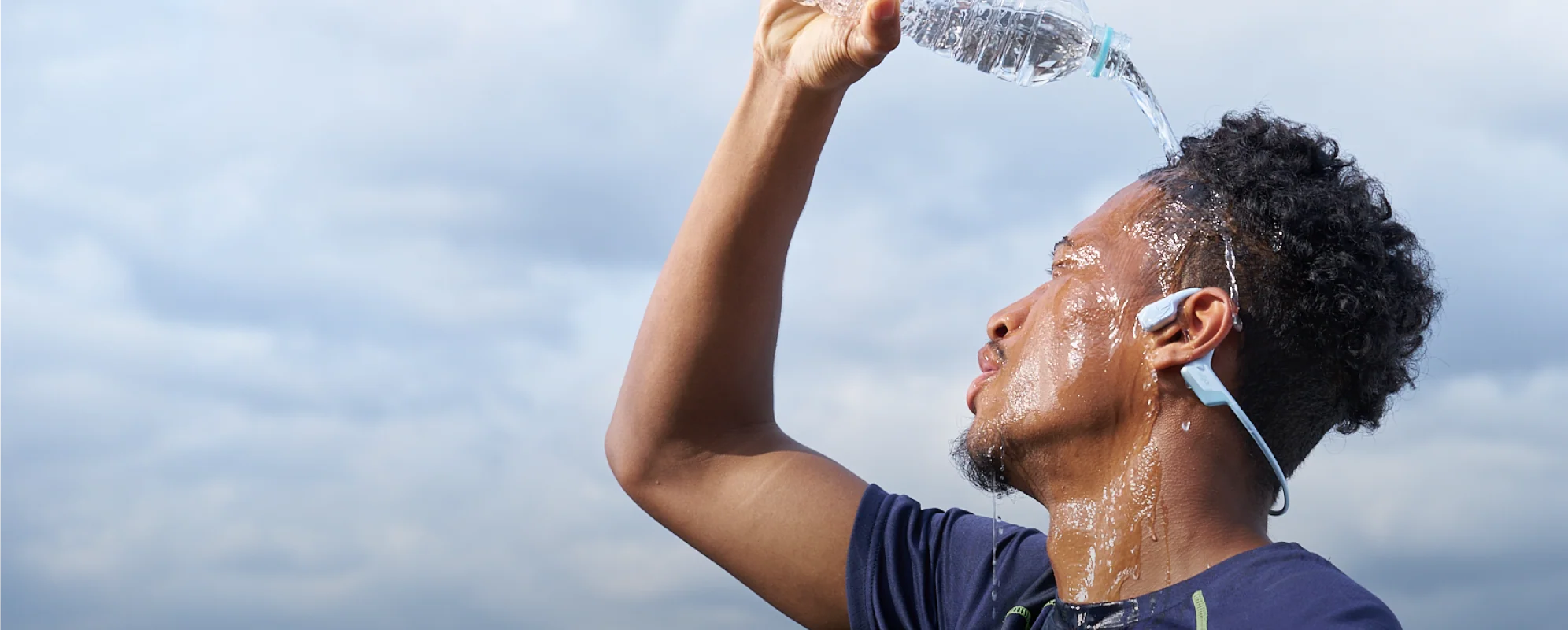 Person pouring water while wearing OpenRun Air 2
